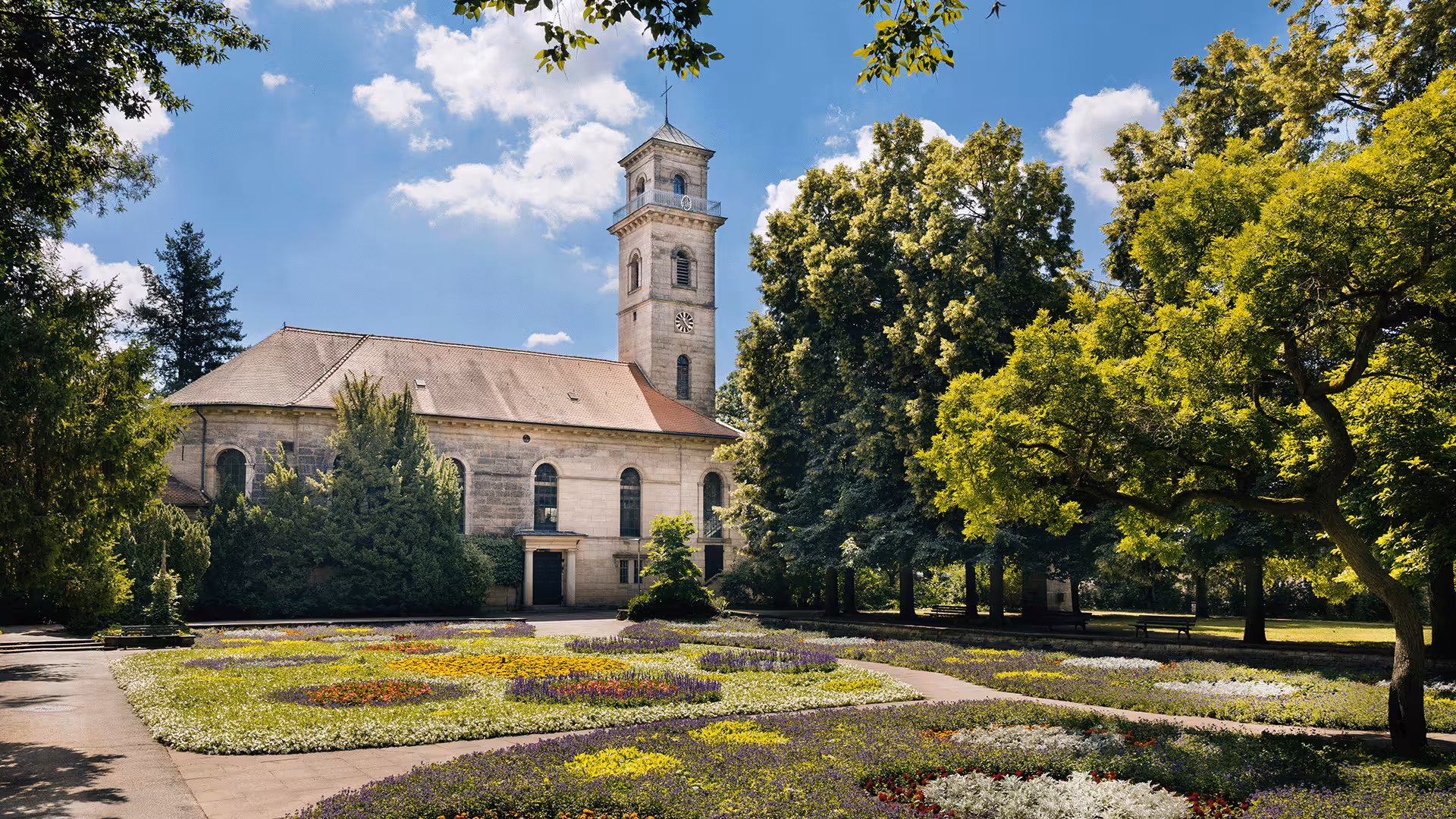 Kirchturm in Fürth, umgeben von Bäumen